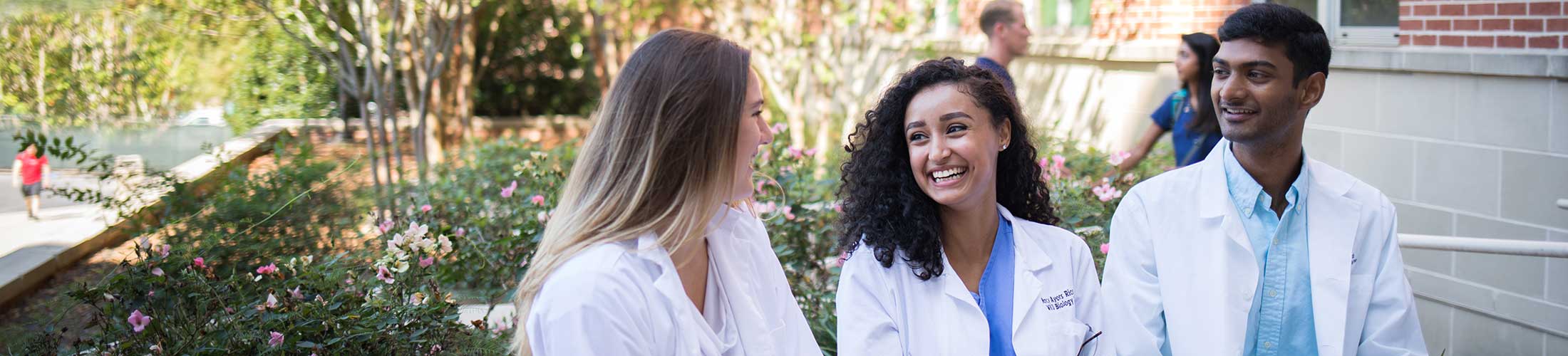 Biomedical students students walking outside of the Allied Health building.