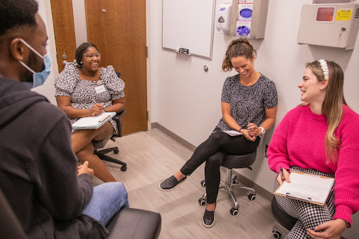 Group of people in medical office talking and taking notes.