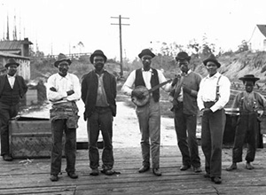 Black and White image of men singing and playing guitar.