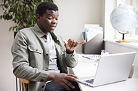 Man using sign language to communicate on a virtual call. 