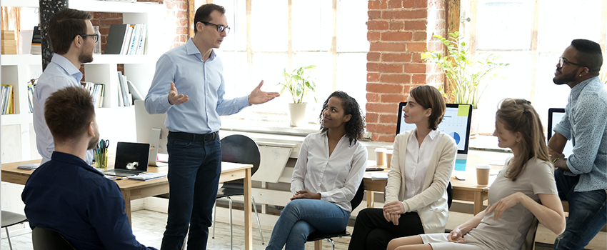 Man standing talking to group of people.