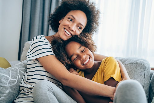 Mom holding daughter smiling.