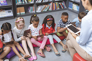 A group of children in the library working with the librarian.