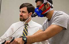 Male with breathing mask on with another male.