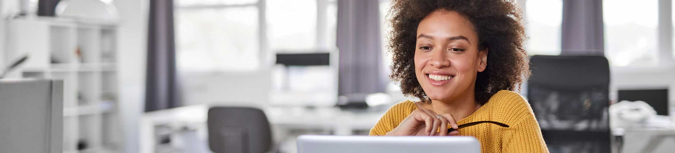 Woman smiling at her desk in her office.