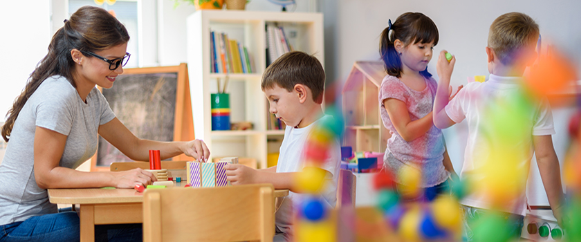 Teacher working with kids with building blocks