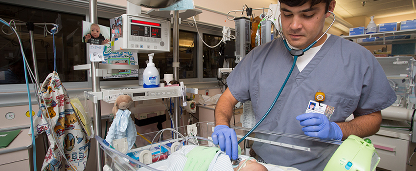 Medical student checking on baby in hospital