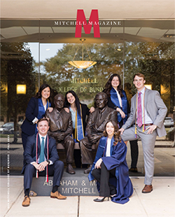 MCOB graduates in front of Abraham Mitchell statue.