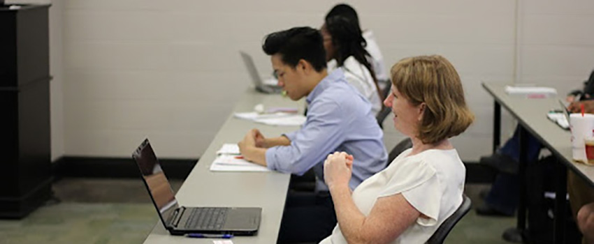 Students working in class on laptops.