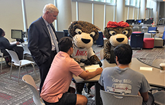 Dr. Waldrop, Southpaw, and Miss Pawla with USA students at a table working