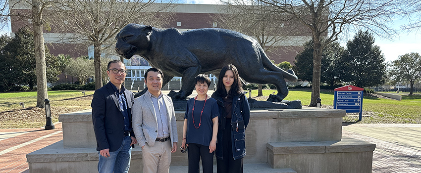 International guests on USA campus in front of Jaguar statue.