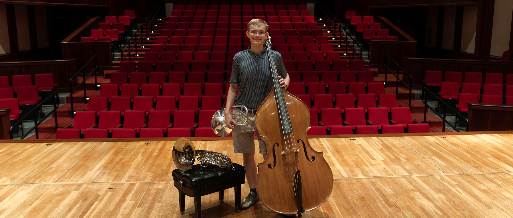 Noah Sugg, the 2024-25 University of South Alabama Board of Trustees Scholar, on the Laidlaw stage with the double bass, French horn, and mellophone.