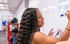 Student writing on whiteboard.